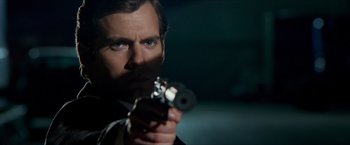 Movie still from “The Man from U.N.C.L.E.” (2015), directed by Guy Ritchie – A person holding a gun; Close Up shot, Over the shoulder angle