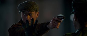 A man in a hat and gloves holding a remote control