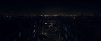 Movie still from “The Man from U.N.C.L.E.” (2015), directed by Guy Ritchie – An aerial view of a city at night with buildings lit up; Extreme Wide shot, High angle