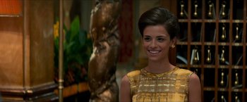 Movie still from “The Man from U.N.C.L.E.” (2015), directed by Guy Ritchie – A woman in a yellow dress smiling for the camera; Close Up shot, Over the shoulder angle