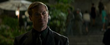 Movie still from “The Man from U.N.C.L.E.” (2015), directed by Guy Ritchie – A person wearing a suit and tie; Close Up shot, Over the shoulder angle