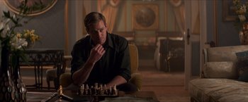 Movie still from “The Man from U.N.C.L.E.” (2015), directed by Guy Ritchie – A man sitting in front of a chess board; Medium shot, Over the shoulder angle