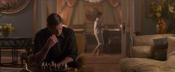 Movie still from “The Man from U.N.C.L.E.” (2015), directed by Guy Ritchie – A man sitting in a chair playing a game of chess; Wide shot, Over the shoulder angle