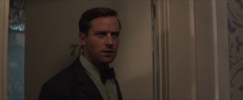 Movie still from “The Man from U.N.C.L.E.” (2015), directed by Guy Ritchie – A man wearing a suit and bow tie in front of a door; Close Up shot, Over the shoulder angle