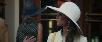 Movie still from “The Man from U.N.C.L.E.” (2015), directed by Guy Ritchie – A woman wearing a white hat and yellow earrings; Close Up shot, Low angle
