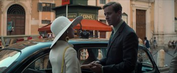 Movie still from “The Man from U.N.C.L.E.” (2015), directed by Guy Ritchie – A man and a woman standing next to each other in front of a car; Medium shot, Over the shoulder angle