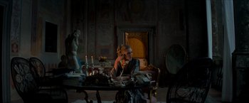 Movie still from “The Man from U.N.C.L.E.” (2015), directed by Guy Ritchie – A woman sitting at a table talking on the phone; Wide shot, Low angle