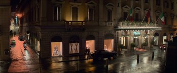 Movie still from “The Man from U.N.C.L.E.” (2015), directed by Guy Ritchie – A couple of people riding bikes in front of a building; Extreme Wide shot, Over the shoulder angle