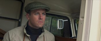 Movie still from “The Man from U.N.C.L.E.” (2015), directed by Guy Ritchie – A person in a car wearing a hat; Close Up shot, Over the shoulder angle