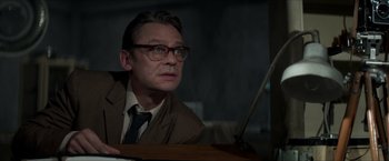 Movie still from “The Man from U.N.C.L.E.” (2015), directed by Guy Ritchie – A man in a suit and glasses looking up; Close Up shot, Low angle