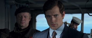 Movie still from “The Man from U.N.C.L.E.” (2015), directed by Guy Ritchie – A person wearing a suit and tie; Close Up shot, Over the shoulder angle