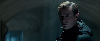 Movie still from “The Man from U.N.C.L.E.” (2015), directed by Guy Ritchie – A person wearing a suit and tie; Close Up shot, Over the shoulder angle
