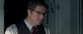 Movie still from “The Man from U.N.C.L.E.” (2015), directed by Guy Ritchie – A person wearing glasses and a tie; Close Up shot, Over the shoulder angle