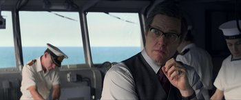 Movie still from “The Man from U.N.C.L.E.” (2015), directed by Guy Ritchie – A man wearing a vest and tie sitting in a vehicle; Close Up shot, Over the shoulder angle
