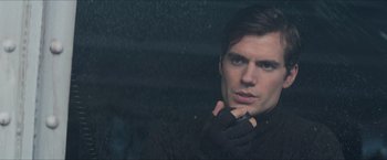 Movie still from “The Man from U.N.C.L.E.” (2015), directed by Guy Ritchie – A man in a black jacket is looking out of a window; Close Up shot, Over the shoulder angle