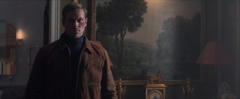 Movie still from “The Man from U.N.C.L.E.” (2015), directed by Guy Ritchie – A man standing in front of a painting in a room; Medium shot, Low angle