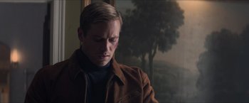 Movie still from “The Man from U.N.C.L.E.” (2015), directed by Guy Ritchie – A man in a brown jacket looking down at his face; Close Up shot, Low angle