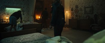 Movie still from “The Manor” (2021), directed by Axelle Carolyn – Two people are standing in a bedroom in the dark; Wide shot, High angle