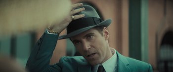 Movie still from “The Many Saints of Newark” (2021), directed by Alan Taylor – A person wearing a suit and a hat; Close Up shot, Over the shoulder angle
