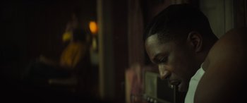 Movie still from “The Many Saints of Newark” (2021), directed by Alan Taylor – A man's face in a dark room; Close Up shot, Over the shoulder angle