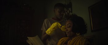 Movie still from “The Many Saints of Newark” (2021), directed by Alan Taylor – A woman with yellow gloves on her head; Close Up shot, Over the shoulder angle