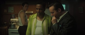 Movie still from “The Many Saints of Newark” (2021), directed by Alan Taylor – A man in a green and white jacket standing next to another man in a black suit; Medium shot, Over the shoulder angle