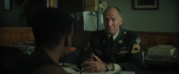 Movie still from “The Many Saints of Newark” (2021), directed by Alan Taylor – A man in a military uniform sitting in front of a mirror; Medium shot, Over the shoulder angle