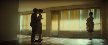 Movie still from “The Many Saints of Newark” (2021), directed by Alan Taylor – A man and a woman kissing in a room; Wide shot, Low angle