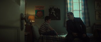 Movie still from “The Many Saints of Newark” (2021), directed by Alan Taylor – Two young men sitting on a bed next to each other; Medium shot, Low angle