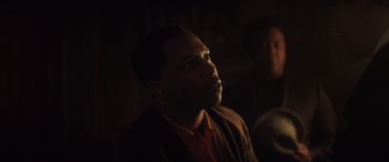 Movie still from “The Many Saints of Newark” (2021), directed by Alan Taylor – A man in a dark room looking up at the sky; Close Up shot, Low angle