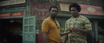 Movie still from “The Many Saints of Newark” (2021), directed by Alan Taylor – Two men standing next to each other in front of a building; Medium shot, Low angle