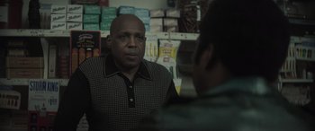 Movie still from “The Many Saints of Newark” (2021), directed by Alan Taylor – A man is talking to another man in a store; Close Up shot, Over the shoulder angle