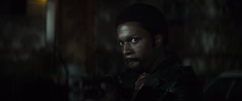 Movie still from “The Many Saints of Newark” (2021), directed by Alan Taylor – A person with a gun in a room; Close Up shot, Over the shoulder angle