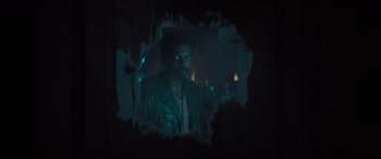 Movie still from “The Many Saints of Newark” (2021), directed by Alan Taylor – A man is standing in a dark room; Medium shot, Over the shoulder angle