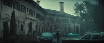 Movie still from “The Many Saints of Newark” (2021), directed by Alan Taylor – A man walking down a street holding an umbrella; Extreme Wide shot, Low angle