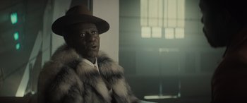 Movie still from “The Many Saints of Newark” (2021), directed by Alan Taylor – A man wearing a fur coat and a brown hat; Close Up shot, Over the shoulder angle