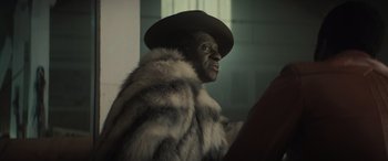 Movie still from “The Many Saints of Newark” (2021), directed by Alan Taylor – A man wearing a fur coat and a hat; Close Up shot, Over the shoulder angle