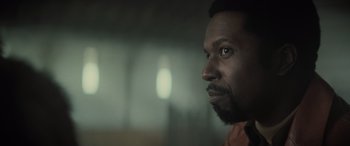 Movie still from “The Many Saints of Newark” (2021), directed by Alan Taylor – A person with a beard looking to his left; Close Up shot, Over the shoulder angle