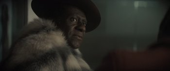 Movie still from “The Many Saints of Newark” (2021), directed by Alan Taylor – A person wearing a hat and a fur coat; Close Up shot, Over the shoulder angle