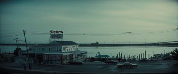 Movie still from “The Many Saints of Newark” (2021), directed by Alan Taylor – Many cars parked in the parking lot; Extreme Wide shot, High angle
