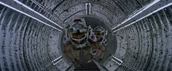 Movie still from “The Martian” (2015), directed by Ridley Scott – Two people in spacesuits standing on a flight of stairs; Wide shot, Overhead angle