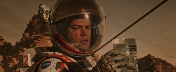 Movie still from “The Martian” (2015), directed by Ridley Scott – A man wearing a helmet is holding something in his hand; Close Up shot, Low angle