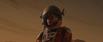 Movie still from “The Martian” (2015), directed by Ridley Scott – A man wearing a space suit and helmet; Close Up shot, Low angle