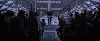 Movie still from “The Martian” (2015), directed by Ridley Scott – A man is giving a speech in front of an audience; Wide shot, Over the shoulder angle