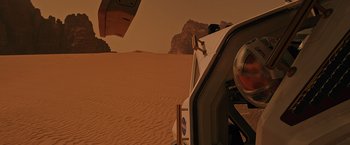 Movie still from “The Martian” (2015), directed by Ridley Scott – A truck driving through the desert on a sunny day; Wide shot, High angle