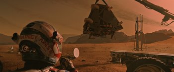 Movie still from “The Martian” (2015), directed by Ridley Scott – An image of an image of a person on the ground in the desert; Extreme Wide shot, Low angle