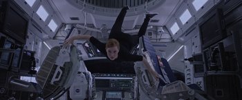 Movie still from “The Martian” (2015), directed by Ridley Scott – A young boy is hanging upside down in a space station; Medium shot, Overhead angle