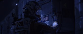 Movie still from “The Martian” (2015), directed by Ridley Scott – A person in a helmet and a glove is standing in a dark room; Close Up shot, High angle