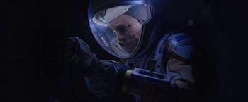 Movie still from “The Martian” (2015), directed by Ridley Scott – A man in a space suit looking at his cell phone; Medium shot, Overhead angle