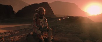 Movie still from “The Martian” (2015), directed by Ridley Scott – A person in a space suit sitting on the ground; Wide shot, Low angle